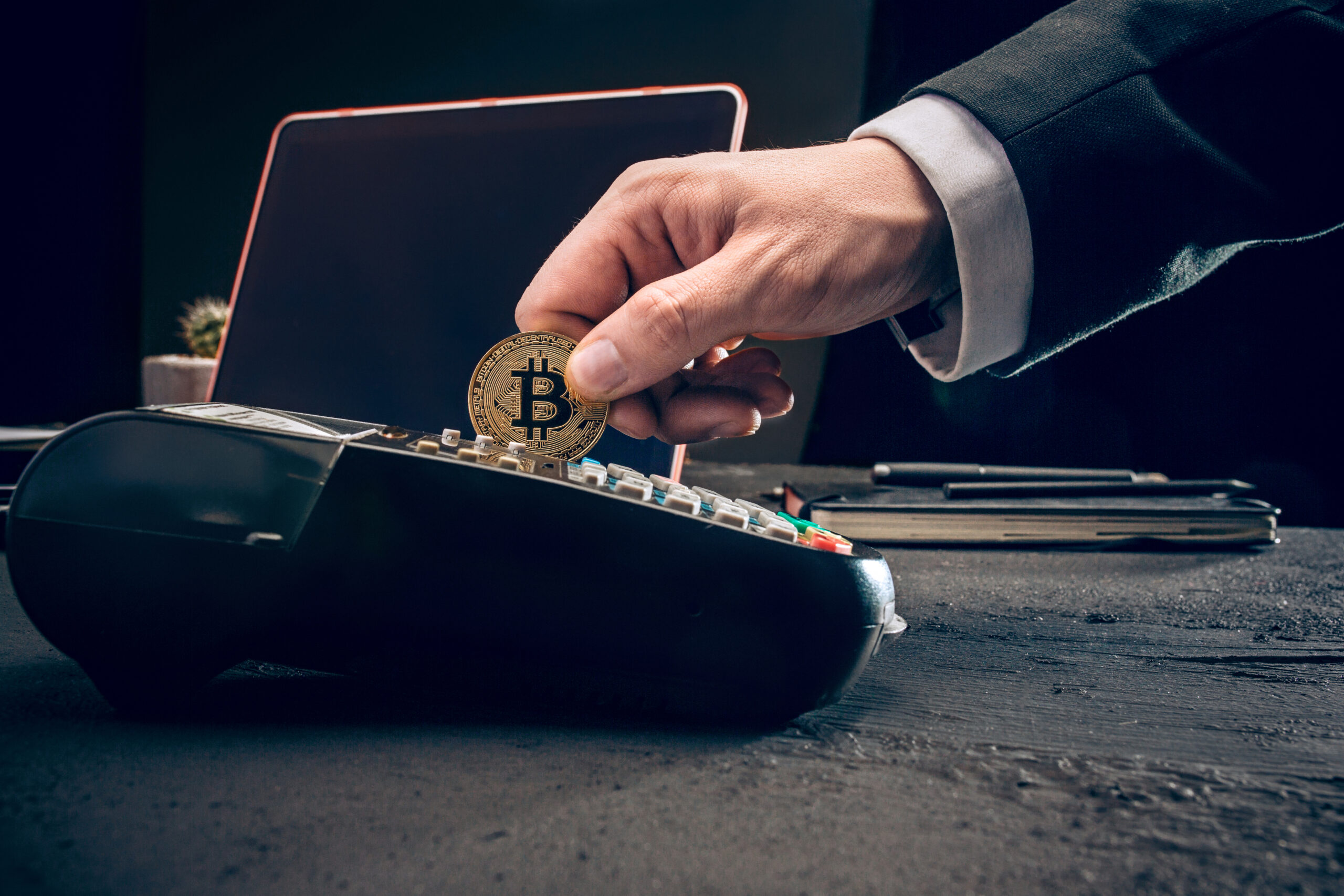 Bitcoin, credit card and POS-terminal. The golden bitcoin in male hands. Cryptocurrency bitcoin coins. Litecoin, Bitcoin, Ethereum, e-commerce, busibess, finance concept. crypto currency symbol. virtual electronic money concepts